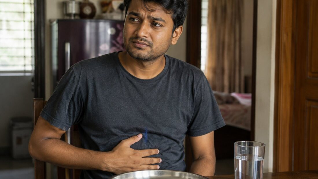 পেটে হাত রেখে বসে থাকা একজন মানুষ